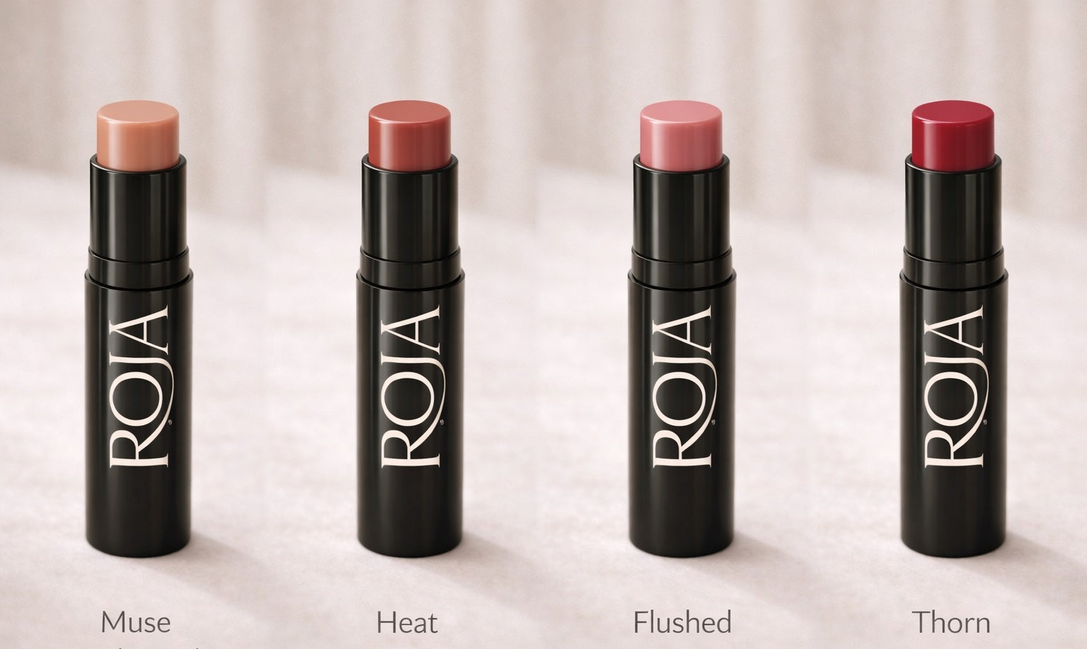 Four Roja lipsticks with different shades on a light background